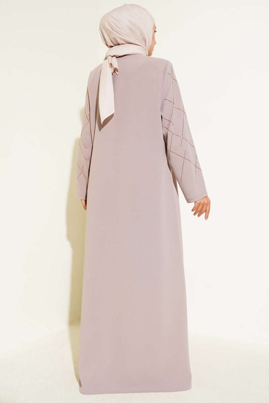 Abaya beige ornée de motifs baklava et dotée d'une fermeture éclair.