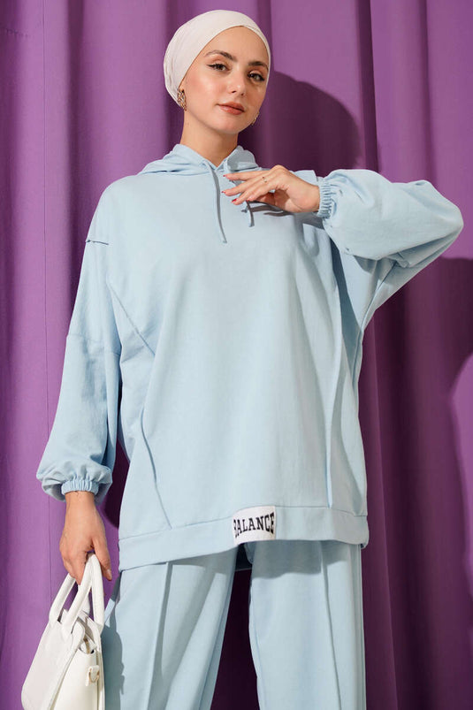 Conjunto informal de dos piezas con capucha y emblema de equilibrio en azul bebé