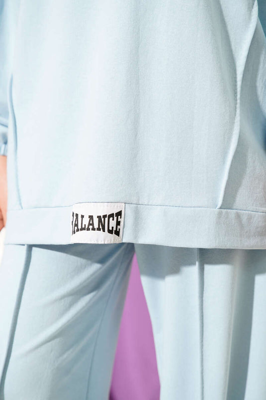 Conjunto informal de dos piezas con capucha y emblema de equilibrio en azul bebé