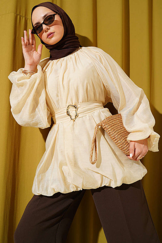 Tunique beige ceinturée avec boucle dorée et manches ballon