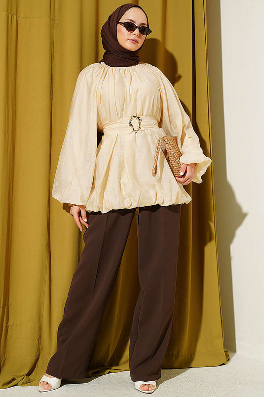 Tunique beige ceinturée avec boucle dorée et manches ballon