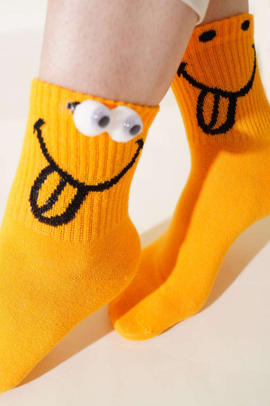 Senfgelbe Socke mit verspieltem Augenhöhlenmotiv
