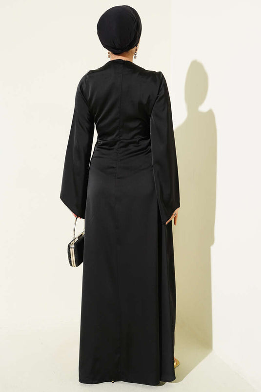 Robe de soirée en satin noir avec détail froncé à la taille.