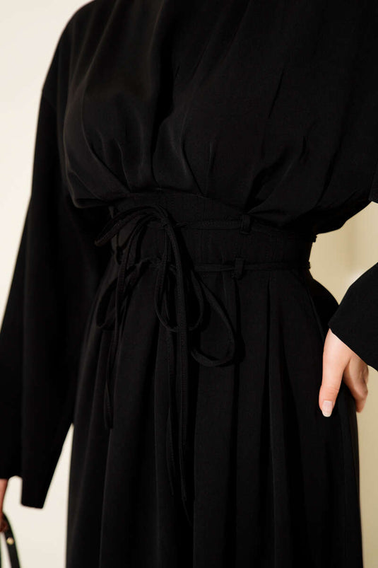 Robe noire à pinces à la taille et ceinture à bretelles