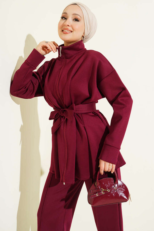 Combinaison deux pièces bordeaux en néoprène, cintrée à la taille et ceinturée.