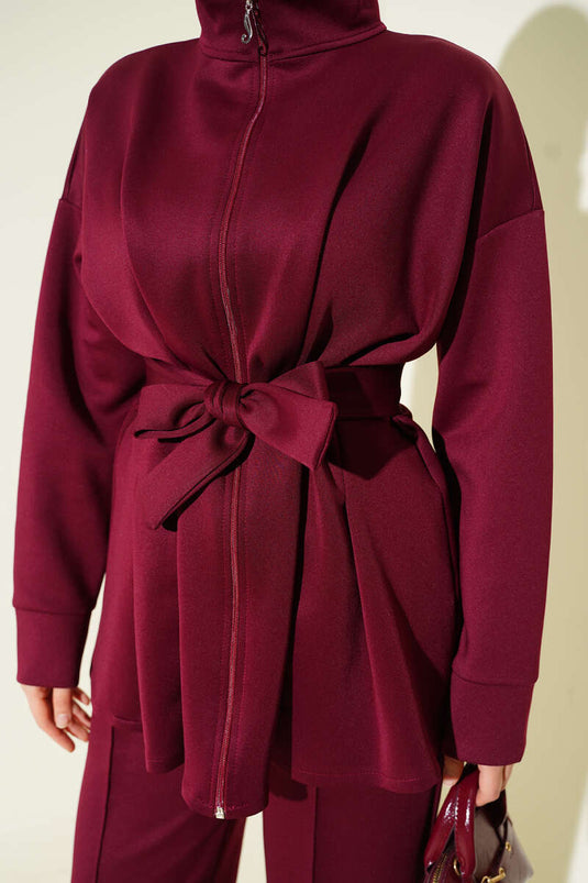 Combinaison deux pièces bordeaux en néoprène, cintrée à la taille et ceinturée.