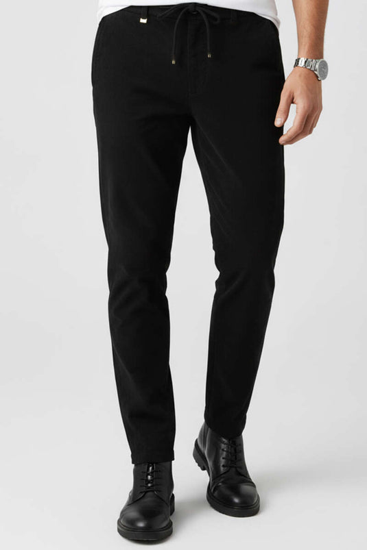 Pantalon en velours noir avec taille élastiquée à cordon.