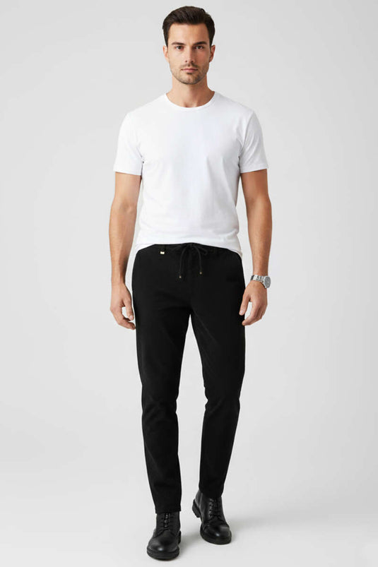 Pantalon en velours noir avec taille élastiquée à cordon.