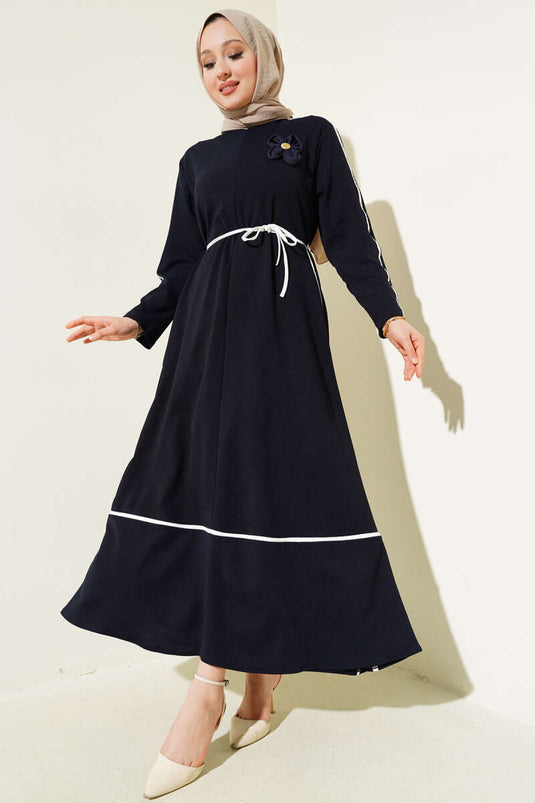 فستان أزرق داكن مع إكسسوار مزهر وتفاصيل حواف