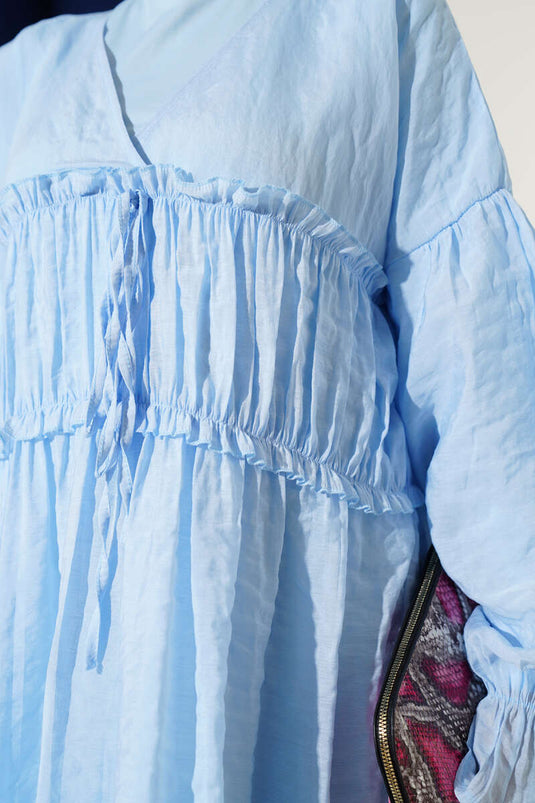 فستان كتان أزرق بفتحة رقبة على شكل حرف V وتفاصيل مجمعة