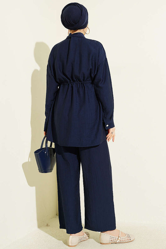 Ensemble deux pièces bleu marine avec ceinture à cordon et fermeture à glissière sur le devant