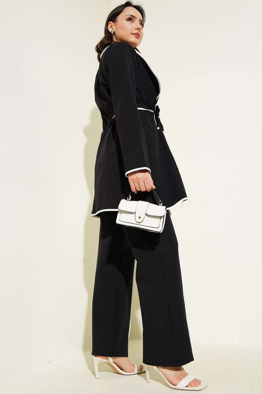 Costume deux pièces à passepoil et accessoire floral noir