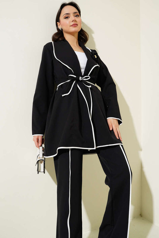 Costume deux pièces à passepoil et accessoire floral noir