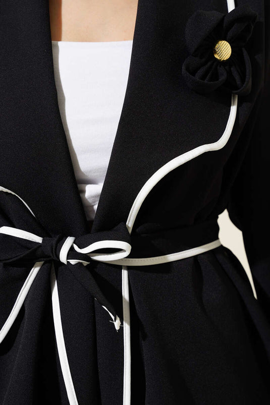 Costume deux pièces à passepoil et accessoire floral noir