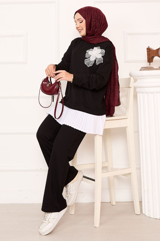 طقم أسود بتنورة بتفاصيل زهرية مع ثنيات وتطريز