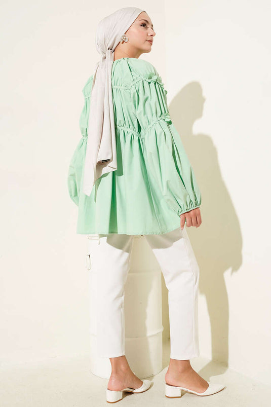 تونيك أخضر بأكمام مرنة وتفاصيل زهور