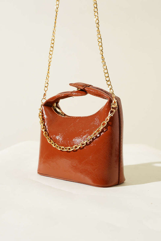 حقيبة جلدية لامعة بمقبض كبس وحزام سلسلة بلون بني