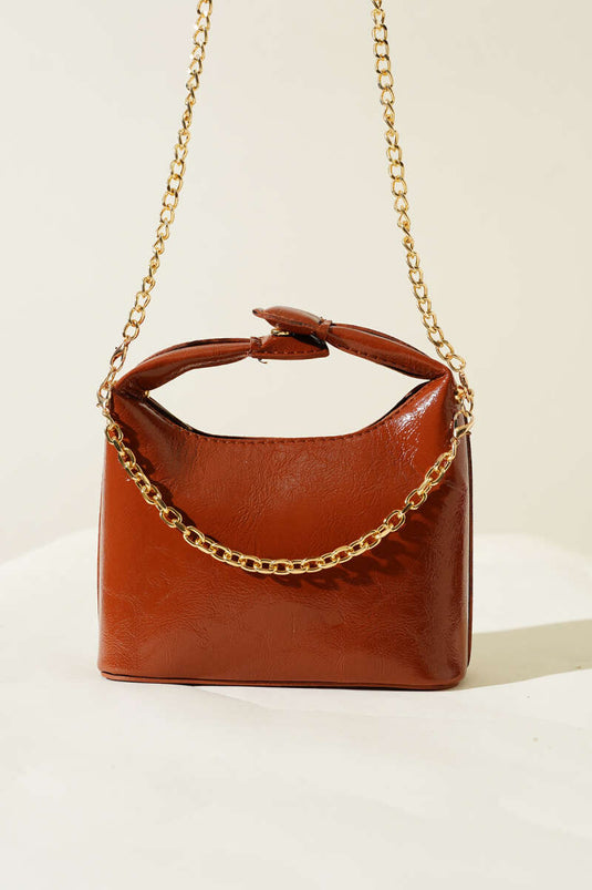 حقيبة جلدية لامعة بمقبض كبس وحزام سلسلة بلون بني