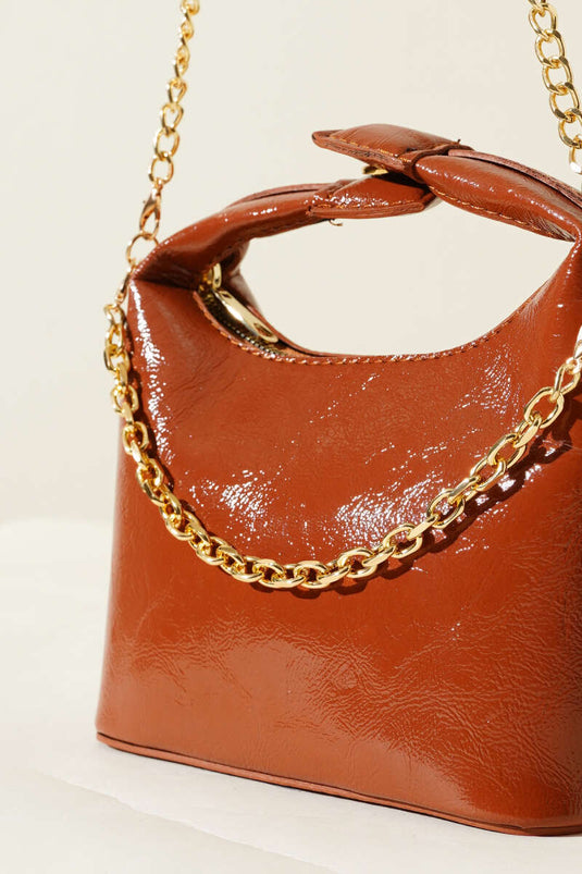 حقيبة جلدية لامعة بمقبض كبس وحزام سلسلة بلون بني