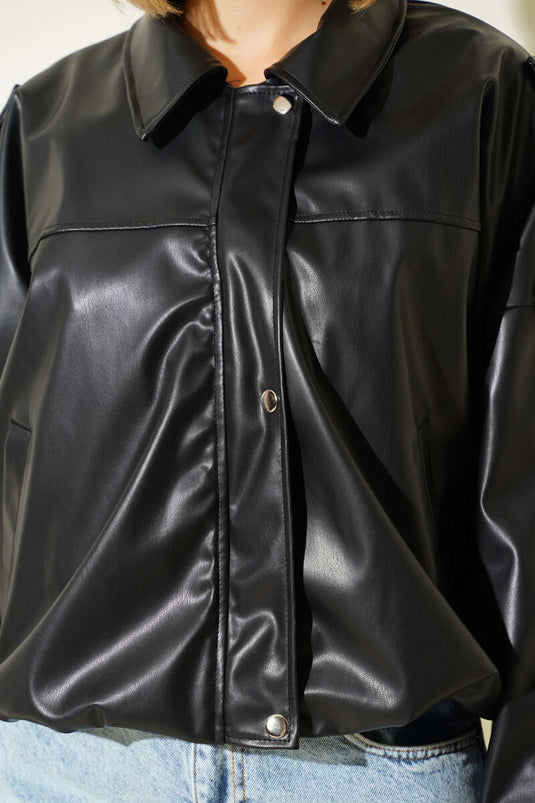 Veste en cuir noire avec fermeture éclair et boutons-pression.