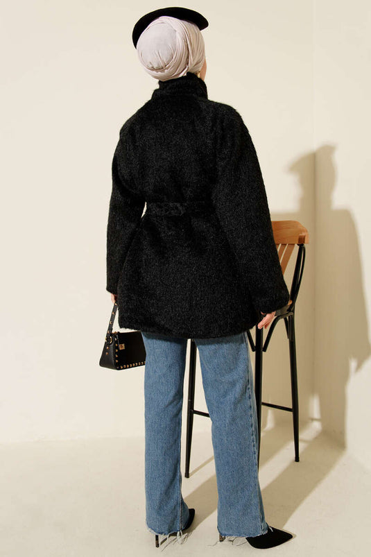 Zwarte jas met opstaande kraag en riem, geschikt voor een baard.