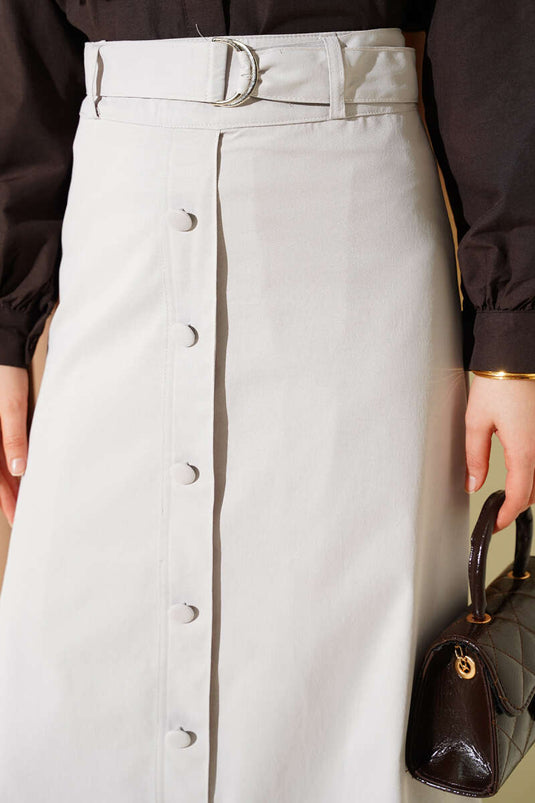 Rockspitze mit Spitzenbesatz und Knopfdetail Stein