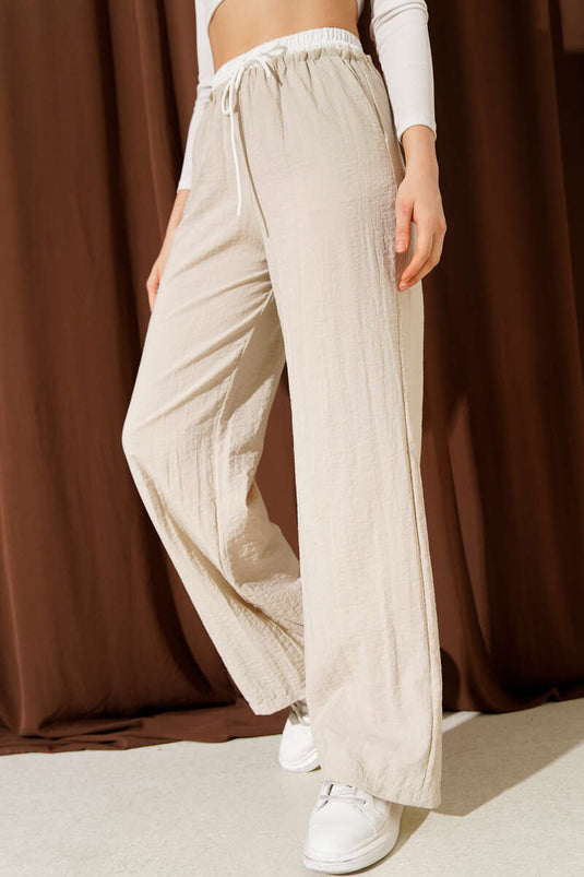 Pantalón beige con cintura fruncida y pernera ancha