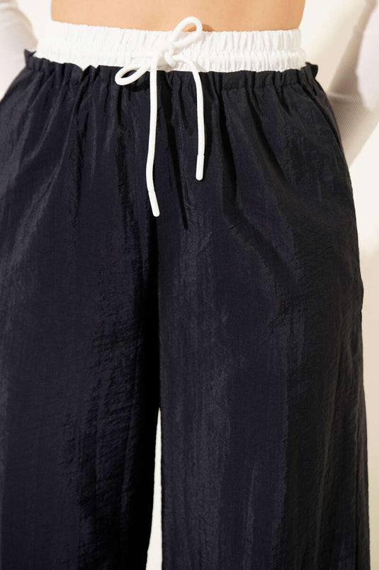 بنطال واسع الساق بحزام عند الخصر باللون الأزرق الداكن