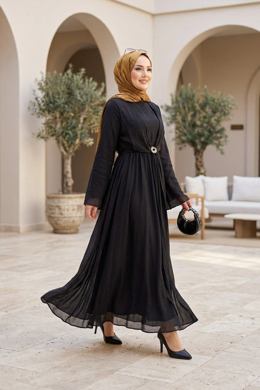 فستان أسود بتصميم واسع مع بروش ذهبي