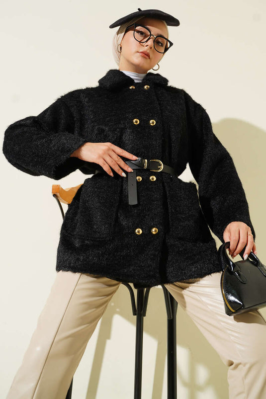 Veste noire à ceinture et boutons dorés, avec barbe apparente.