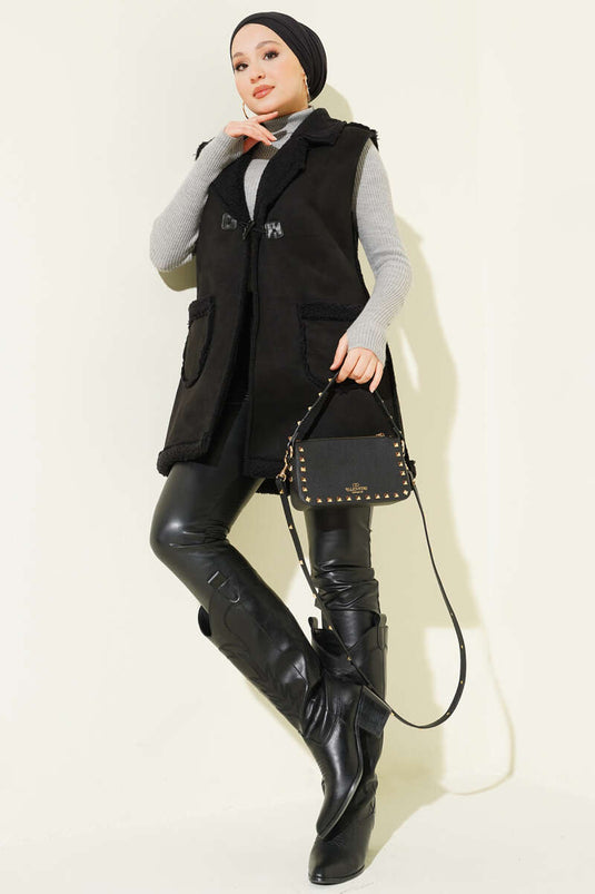 Gilet en daim noir, doublé de fourrure et doté de poches.