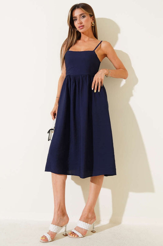 فستان فضفاض ذو حمالات رفيعة باللون الأزرق الداكن.