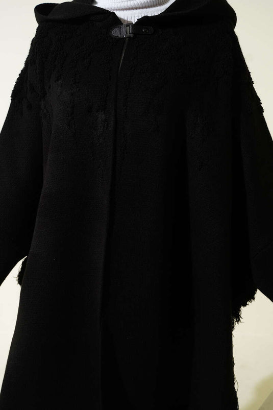 Schwarzer Kapuzenponcho mit geprägtem Muster und Quasten