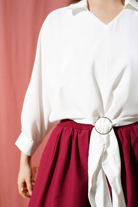 بلوزة بيضاء مزينة بإبزيم الحزام