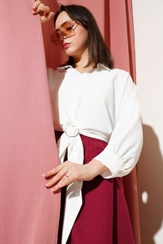 بلوزة بيضاء مزينة بإبزيم الحزام