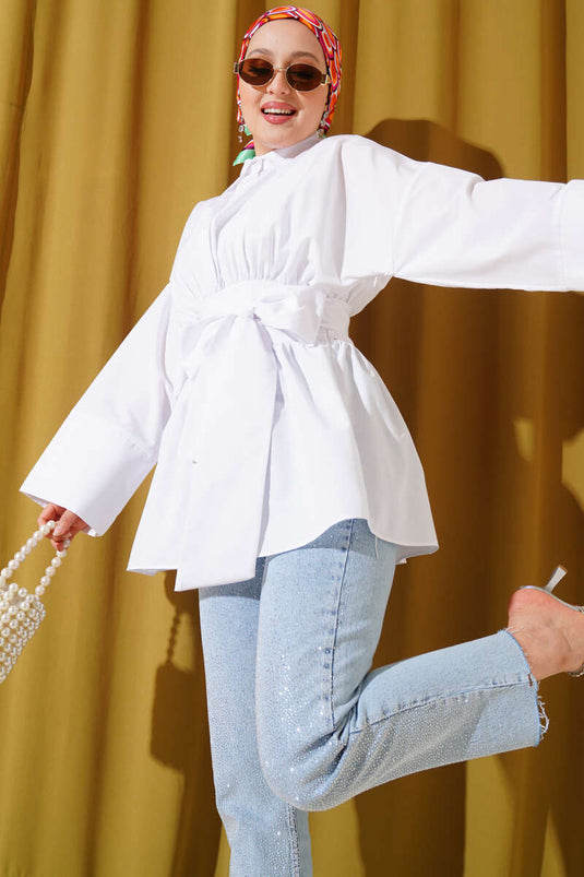 Tunique blanche à ceinture intégrée et froncée sur le devant.