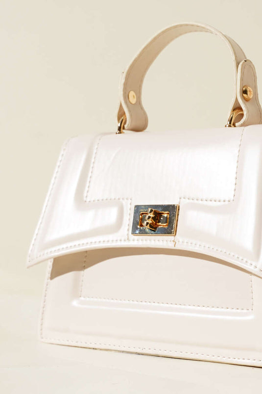 Cream-colored bag with lock detail and edge stitching.