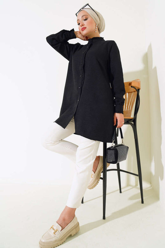 قميص أسود بتفاصيل كشكشة وأكمام وياقة