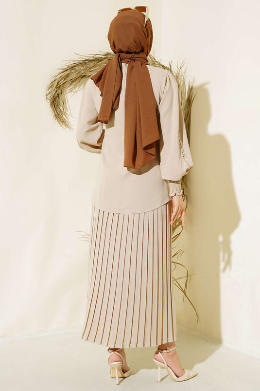 Tailleur en crêpe beige orné de pierres sur les côtés des manches