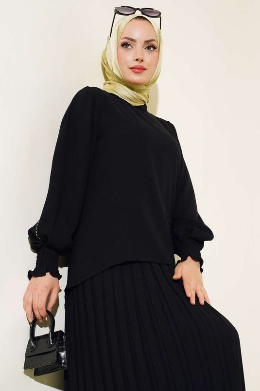 Tailleur en crêpe noir orné de pierres sur les côtés des manches