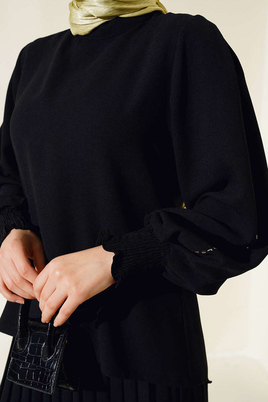 Tailleur en crêpe noir orné de pierres sur les côtés des manches