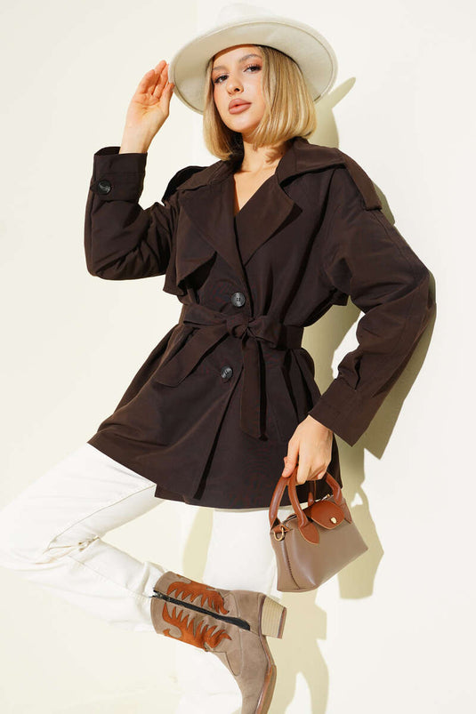 معطف قصير بني اللون، ذو صفين من الأزرار وحزام.