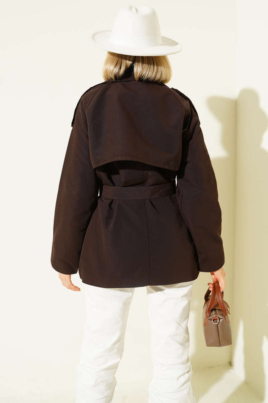 معطف قصير بني اللون، ذو صفين من الأزرار وحزام.