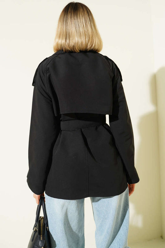 معطف قصير أسود اللون، ذو صفين من الأزرار وحزام.