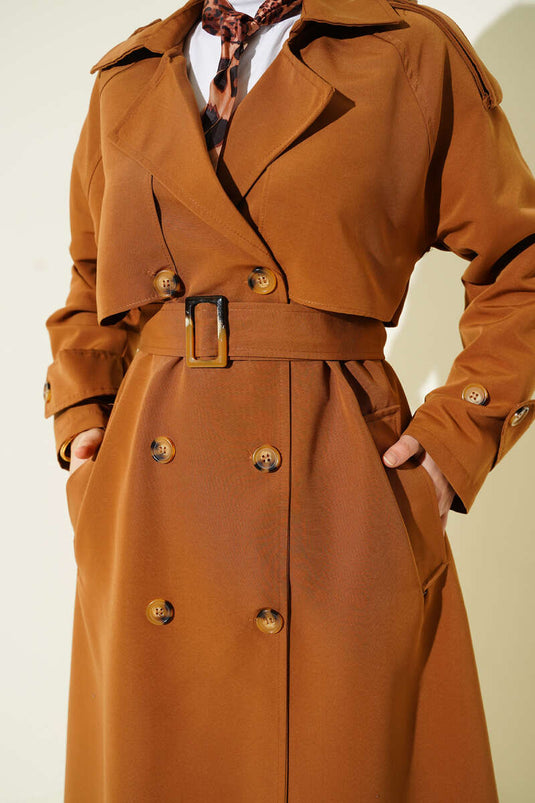 Trench-coat croisé avec cape et ceinture, couleur beige.
