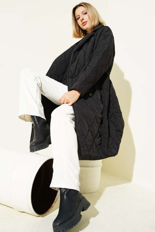 معطف أسود مبطن بحزام، ذو صفين من الأزرار.