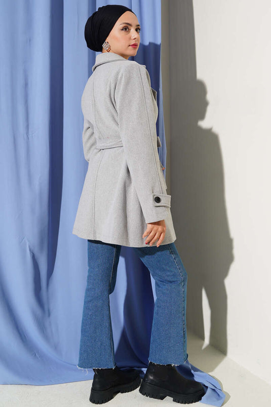 معطف قصير من الكشمير، رمادي اللون، بياقة مزدوجة الصدر وتفاصيل حزام.