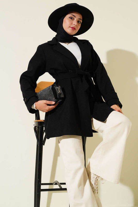 معطف قصير من الكشمير، أسود اللون، بياقة مزدوجة الصدر وتفاصيل حزام.