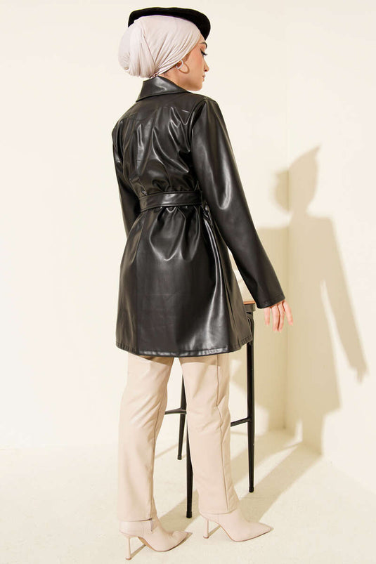 Trench-coat court en cuir noir, croisé et ceinturé.