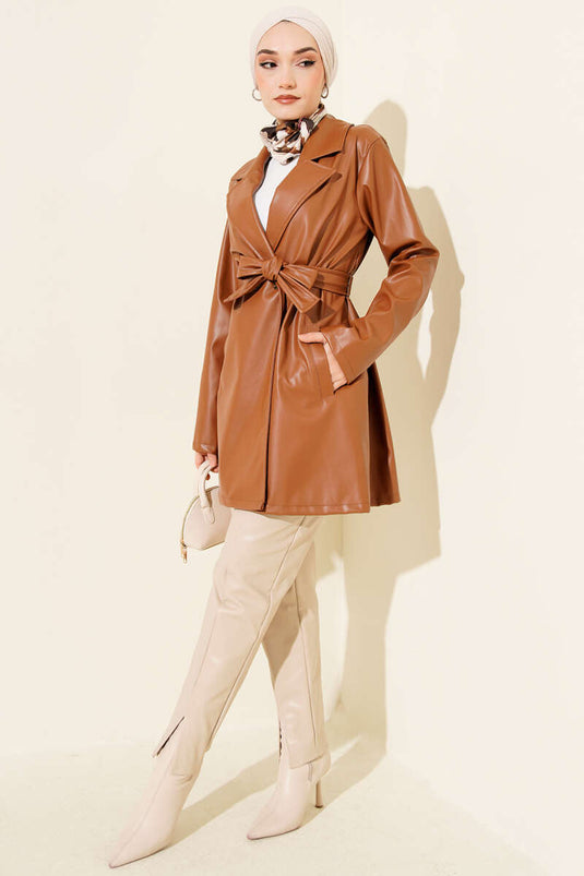 Trench-coat court en cuir beige à double boutonnage et ceinture.